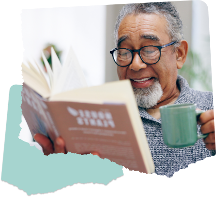 A man reading a book and drinking coffee